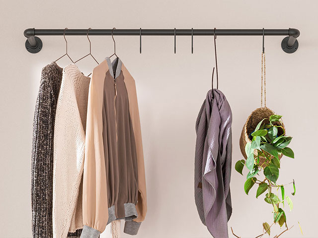 Kleiderstange Wandmontage mit Kleidung und Pflanze